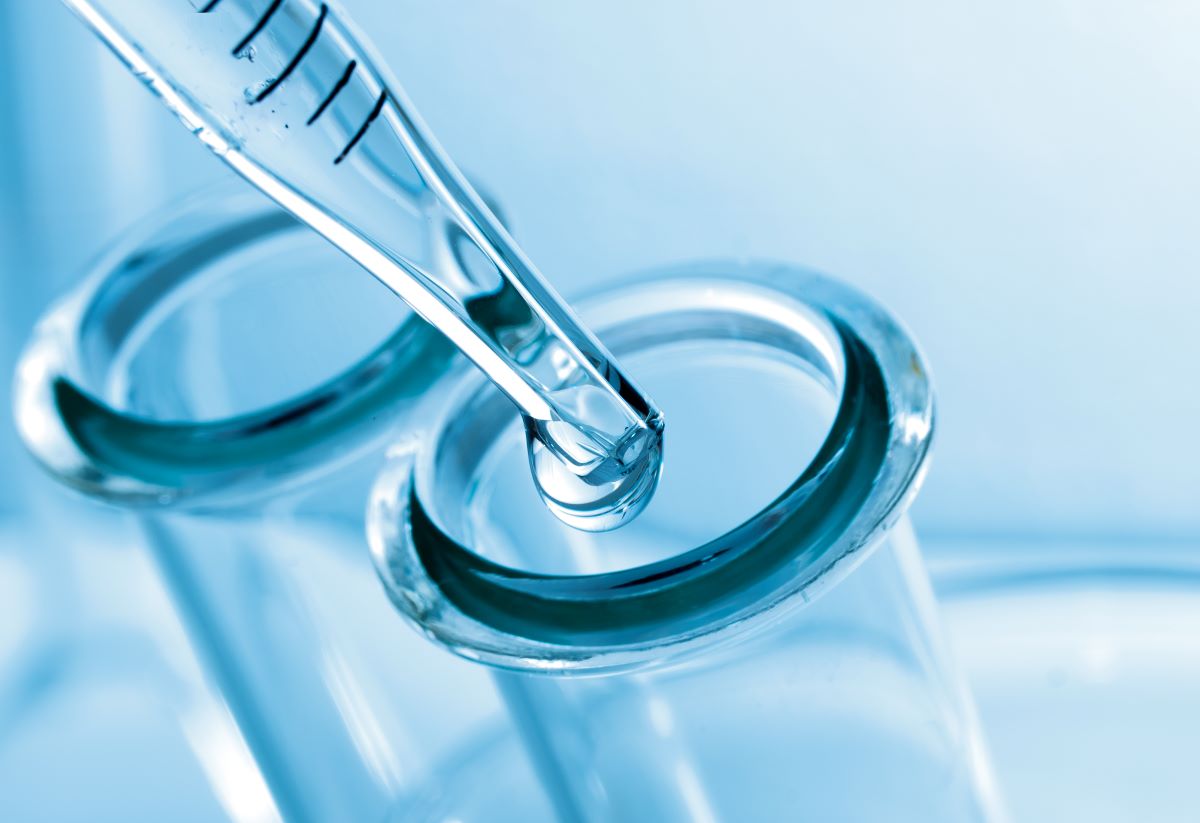Liquid being dripped into a test tube opening
