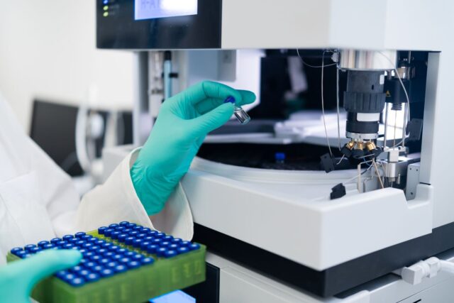 Lab technician placing samples into a machine